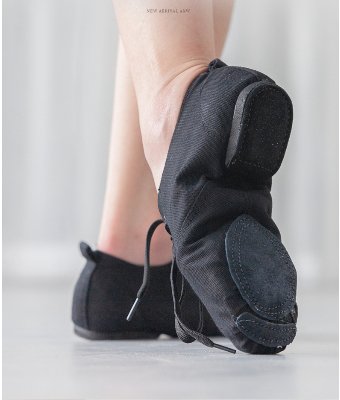 Close-up of canvas jazz dance shoes, showing lace-up closure and split suede sole for dancing